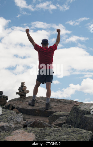 Ein männlicher Wanderer auf einem Berg mit einem Cairn; Lake Louise, Alberta, Kanada Stockfoto