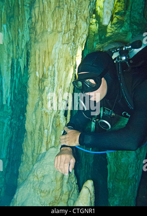 Taucher in der Nähe eines Spalte Felsformationen in Dos Ojos, eine der vielen Cenoten Menschen tauchen in Akumal, Mexiko können Stockfoto