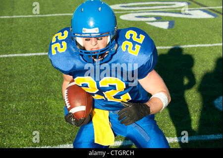 Kaukasische Fußballspieler mit Ball laufen Stockfoto
