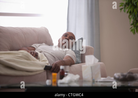 Kranke schwarze Mann Verlegung auf sofa Stockfoto