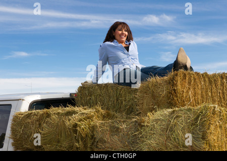 Hispanische Frau sitzen auf Heuballen Stockfoto