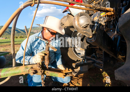 Hispanische Landwirt arbeiten an Traktor Stockfoto