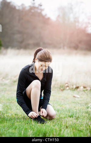 Asiatische Frau ihre Schuhe binden Stockfoto