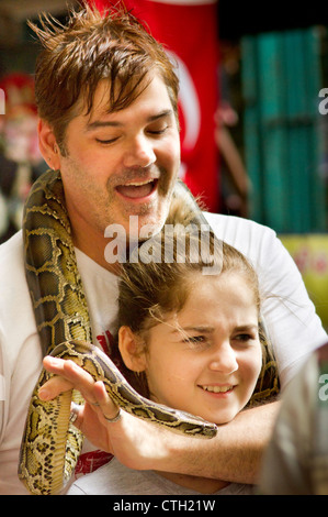 Kaukasische Touristen posierte mit Pythons Schlange in Batu Höhle, Kuala Lumpur, Malaysia. Stockfoto