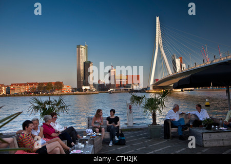 Die Niederlande, Rotterdam. Menschen entspannen im Café im Freien, in der Nähe von Brücke namens Erasmusbrücke, Architekten Ben van Berkel. Stockfoto