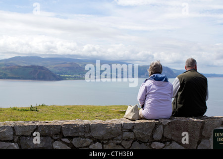 Mann und Frau sitzen in einer Wand Blick auf der walisischen Küste von den Great Orme in Llandudno Nord-Wales Stockfoto