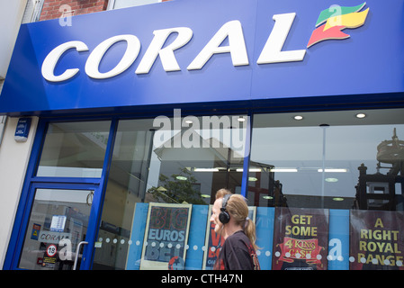 Mann zu Fuß vorbei an einem Korallen Buchmacher-shop Stockfoto