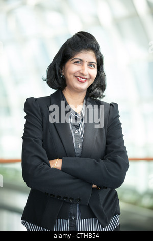 Porträt einer glücklich indischen Geschäftsfrau Stand mit verschränkten Armen. Stockfoto