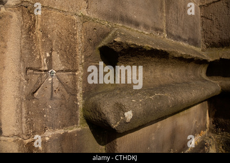 Ordnance Survey Vermesser Benchmark gemeißelt in Stein an der Wand am Eingang zum Lancaster Priorat in Lancaster, England Stockfoto