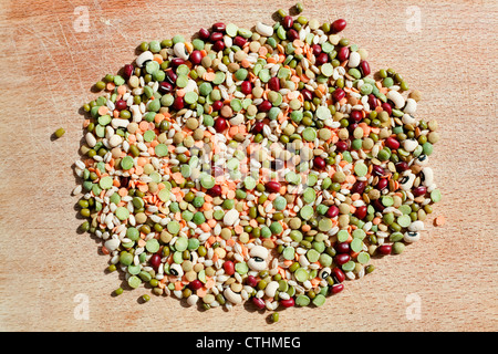 Mix aus verschiedenen getrockneten Bohnen für italienische Linsensuppe auf Holzbrett in Sommertag Stockfoto