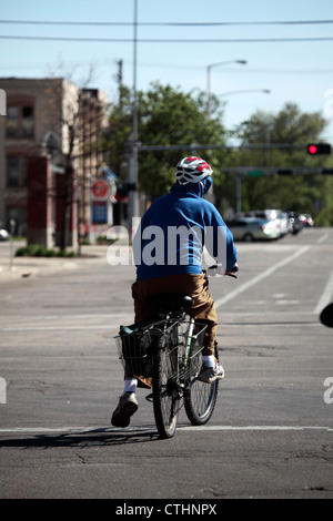 Mann trägt Helm auf dem Fahrrad in Richtung Radweg zieht aus dem Stillstand. Stockfoto