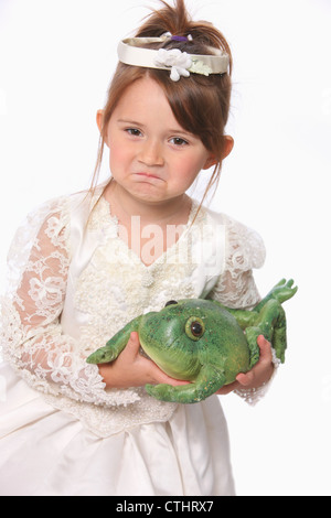 Junges Mädchen In weißen Prinzessin Kleid hält einen grünen Frosch; Troutdale, Oregon, Vereinigte Staaten von Amerika Stockfoto