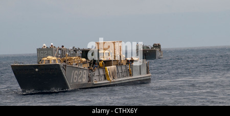 ) drei Landungsfahrzeuge, die Assault Craft Unit (ACU) 1 zugewiesen wurden, nähern sich dem Brunnendeck des amphibischen Sturmschiffes USS Peleliu (LHA 5). Peleliu ist das Flaggschiff der Peleliu Amphibious Ready Group und führt derzeit eine Kompositübung im Pazifik mit dem amphibischen Hafenlandungsschiff USS Rushmore (LSD 47) der Whidbey Island-Klasse und dem amphibischen Transportdockschiff USS Green Bay (LPD 20) durch. Stockfoto