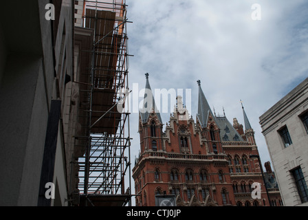 Gebäude mit Gerüst vor St. Pancras Station gegen wispy Wolken und blauer Himmel Stockfoto