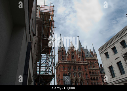 Gebäude mit Gerüst vor St. Pancras Station gegen wispy Wolken und blauer Himmel Stockfoto