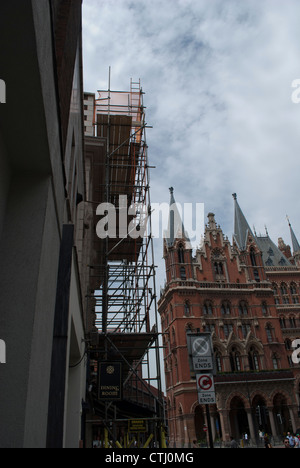 Gebäude mit Gerüst vor St. Pancras Station gegen wispy Wolken und blauer Himmel Stockfoto