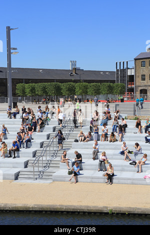 Eine sonnige Mittagspause für Arbeitnehmer auf den Stufen des Granary Square NC1, in des Königs Cross Regeneration Bereich Stockfoto