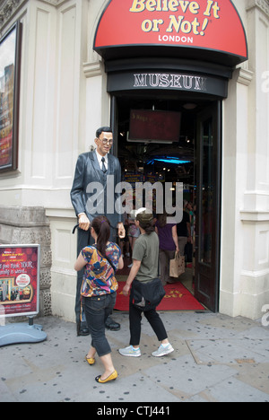 Touristen auf der Suche an der Statue von Robert Pershing Wadlow außerhalb Ripleys glauben es oder nicht! am Piccadilly Circus in London Stockfoto