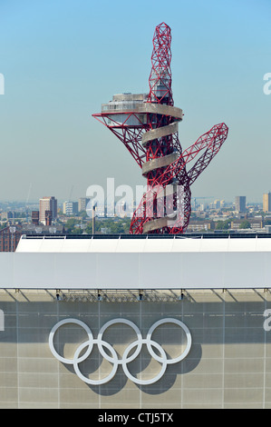 Olympischen Ringe auf die Aquatics Centre mit der ArcelorMittal Orbit Turm über die Olympischen Spiele 2012, Stratford, Newham Park East London England Großbritannien Stockfoto