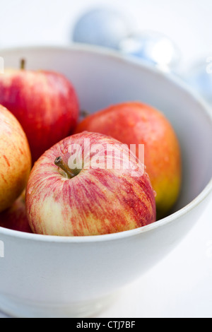 Nahaufnahme einer weißen Schüssel voller Weihnachten Äpfel Stockfoto