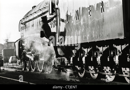 Ein Fahrer klettert an Bord London North Eastern Railway (LNER) Gresley Klasse A4 Dampf Lok Nummer 4498 benannt nach seinem Erbauer "Sir Nigel Gresley." Die erhaltene Dampflokomotive wurde auf der Great Central Railway in Loughborough. Stockfoto