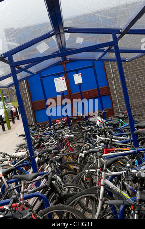 Fahrräder parken auf einem Parkplatz vor einem Bahnhof in England sicher undercover. Stockfoto
