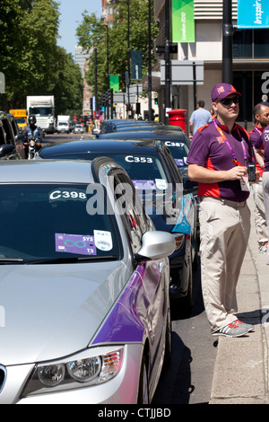 LOCOG Chauffeure warten auf Internationale Olympische Komitee Mitglieder außerhalb Hilton Park Lane Hotel, London, Mittelengland. Stockfoto