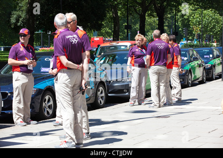 LOCOG ehrenamtlichen Chauffeure warten auf Internationale Olympische Komitee Mitglieder außerhalb Hilton Park Lane Hotel, London, England. Stockfoto
