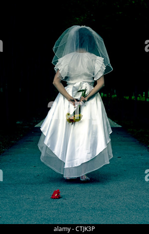 eine Frau in einem Hochzeitskleid ist Fuß durch eine dunkle Gasse Stockfoto