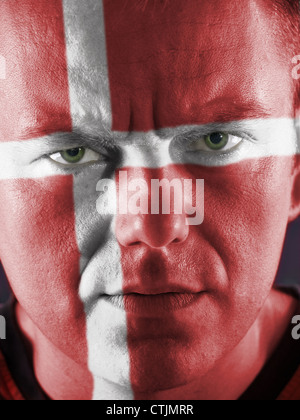 Nahaufnahme des jungen dänischen Anhänger Gesicht bemalt rot mit weißem Kreuz Stockfoto