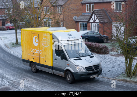 Ocado Lieferwagen liefern Lebensmittel auf eine Wohnsiedlung auf einem kalten, winterlichen Tag in England. Stockfoto