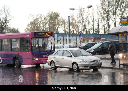 Taxis und Busse warten vor einem Bahnhof auf einem nassen und regnerischen Tag in England. Stockfoto