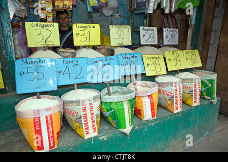 Taschen von halbgeschliffenem Reis zum Verkauf auf einem Markt in den Philippinen. Stockfoto