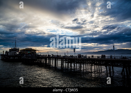 Touristen auf dem Santa Monica Pier im Juli 2012 mit Wolken von Orkan Fabio overhead Stockfoto