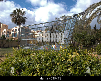 Einkaufswagen in einem Blumenbeet, Riviera del Sol, Costa Del Sol, Provinz Malaga, Andalusien, Spanien, Westeuropa aufgegeben. Stockfoto