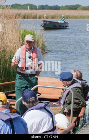 Norfolk Wildlife Trust. Wasser-Trail Guide und Elektroboote mit Besuchern an Bord. Hickling Broad Naturschutzgebiet. Norfolk NNR Stockfoto