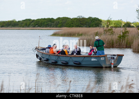 Norfolk Wildlife Trust Wasser Trail Guide und Elektroboot "Schwalbenschwanz", mit den Besuchern an Bord. Hickling Broad Naturschutzgebiet Stockfoto