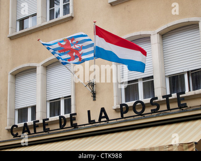 Die Luxemburger Nationalflaggen, links die Flagge des Großherzogs, winken auf ein Café in Vianden. Stockfoto