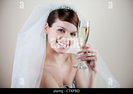 Eine junge Braut mit einem Glas Champagner Stockfoto
