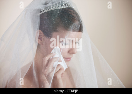 Eine junge Braut Tränen aus ihrem Gesicht mit einem Tuch abwischen Stockfoto