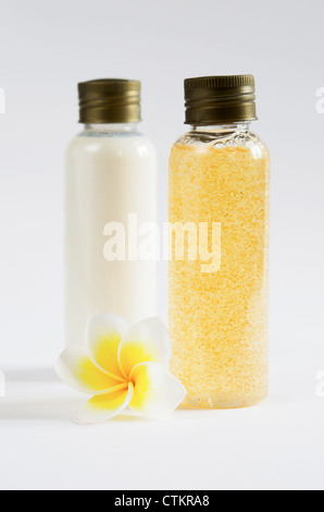 zwei Flaschen und frischen Frangipani auf weißem Hintergrund Stockfoto