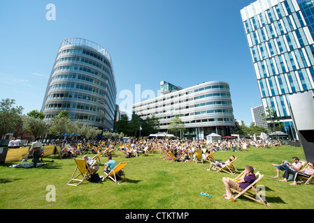 Menschen entspannen Sie an einem sonnigen Sommertag im Spinningfields von Manchester. Stockfoto