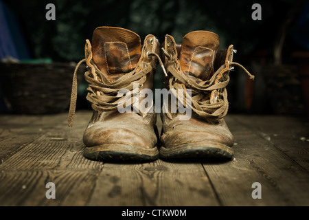 Paar alte Stiefel auf Holzdielen getragen Stockfoto