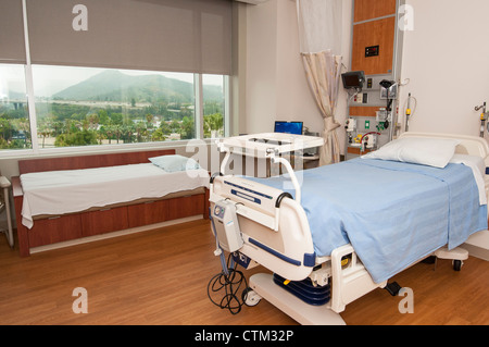 Ein großes modernes Krankenhauszimmer mit Blick auf die Stadt außerhalb. Stockfoto