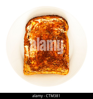 Eine Scheibe Toast ausgesät und Marmite auf weißem Hintergrund Stockfoto