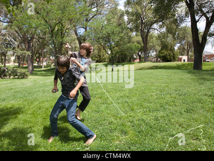 Jungen, die einander angreifen mit dummen String (flüssige Spray Latex) in einem Park, USA. Stockfoto