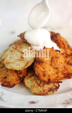 Kartoffelpuffer (Jiddisch: Latkes oder Latkas) traditionell gegessen während Chanukkah mit Soar Creme Stockfoto