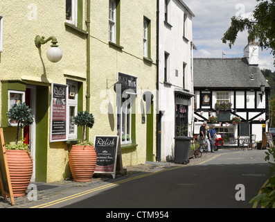 Blick auf die enge Straße zum Queens Head Inn Pub im Sommer Hawkshead Village Cumbria England Großbritannien GB Großbritannien Stockfoto