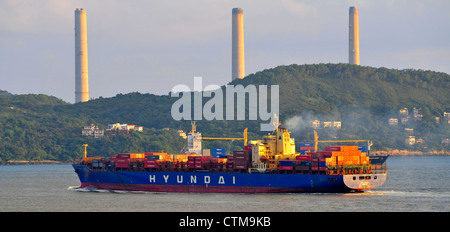 Containerschiffe, die Transport von Fracht und Lamma Insel Kraftwerk Schornsteine, Victoria Harbour, Hong Kong, China. Stockfoto