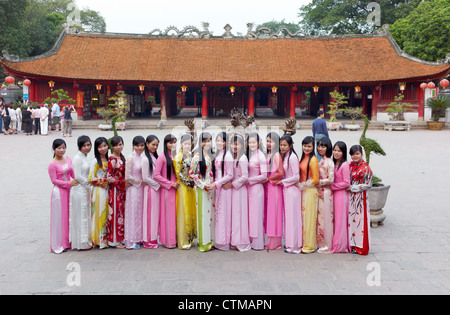 Eine Gruppe von jungen Frauen, gekleidet in traditionellen Ao Dai Kleidern posieren für Fotos in The Temple of Literature Stockfoto